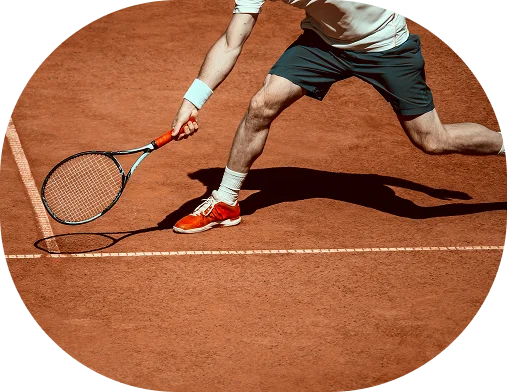A tennis player executes a dynamic forehand shot on a clay court, highlighting speed, coordination, and technique during an intense rally moment